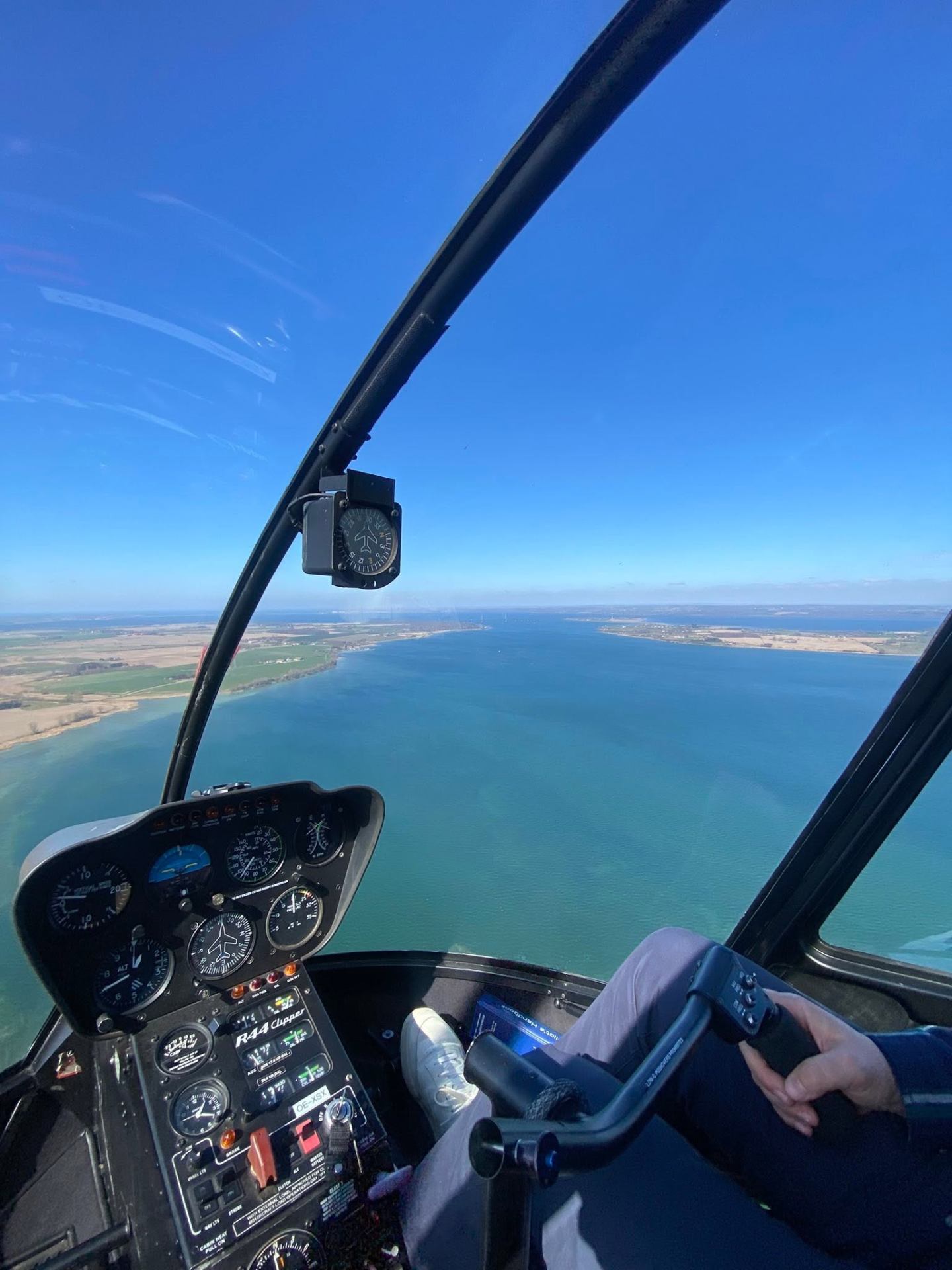 Udsigt fra cockpittet i en helikopter over kysten